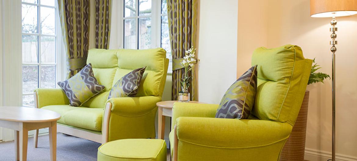 The stylish lounge at Iffley Residential and Nursing Home has relaxing chairs, TV and real fire.