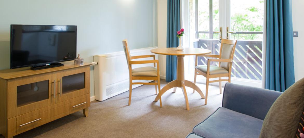 An example Shaftesbury Court Residential Care Home living room with a sofa and TV.