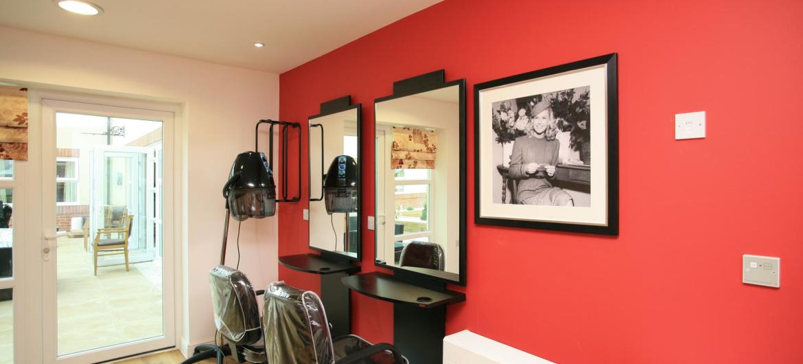 The contemporary hair dressing salon at Park View Residential Care Home has stylish red and black fittings.
