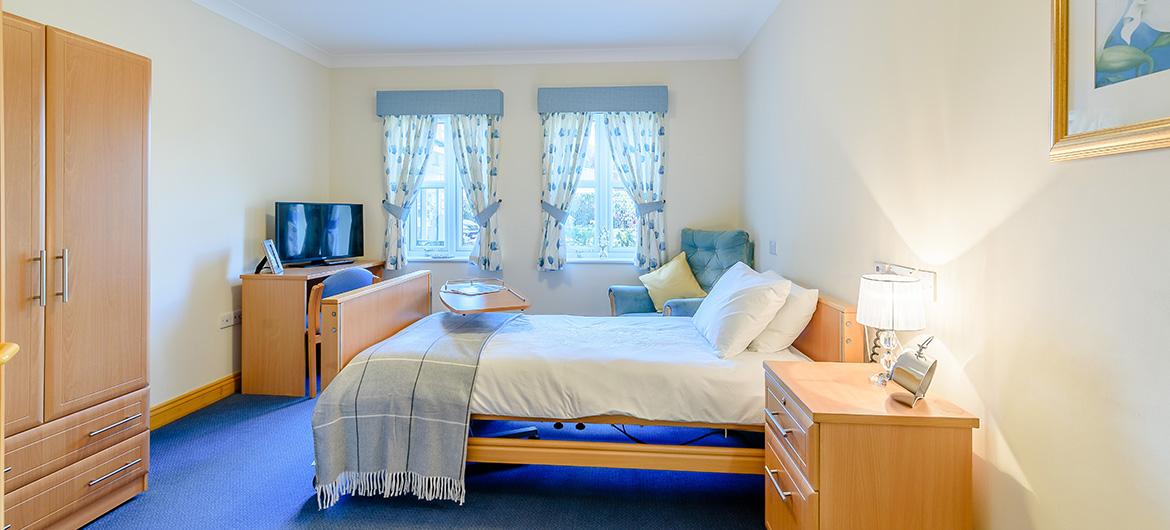 Spacious bedroom with furnishings at Wantage Care Home in Oxfordshire