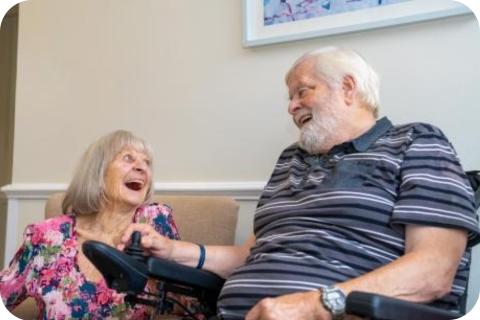 A male and female resident laughing together