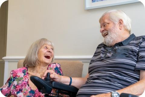 A male and female resident laughing together