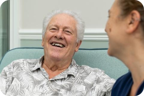 A male resident and carer laughing together