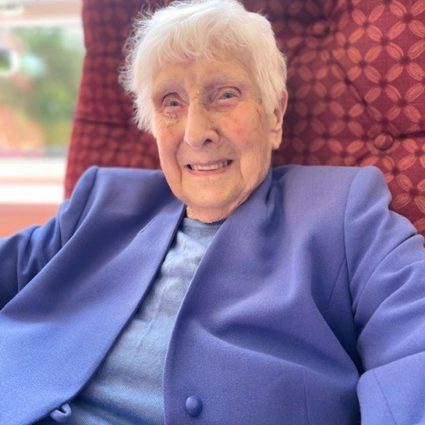 Brambes residential care home resident Lorna, sat smiling in an arm chair