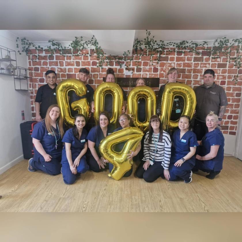 Forefaulds celebrate their Good CQC report A group of people smiling holding gold balloons that say 'Good 4'.