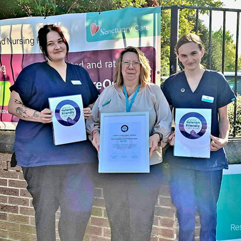 Care home staff at The Park Residential and Nursing Home in Chaddesden stand in front of the care home holding signs celebrating their veteran friendly status