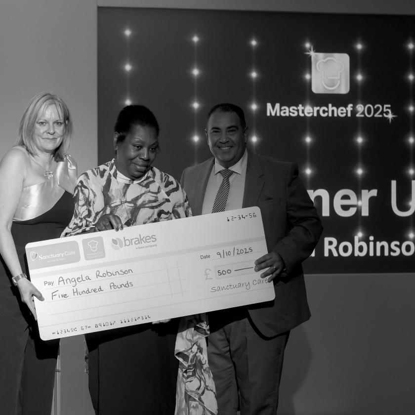 Staff stood together smiling with cheque