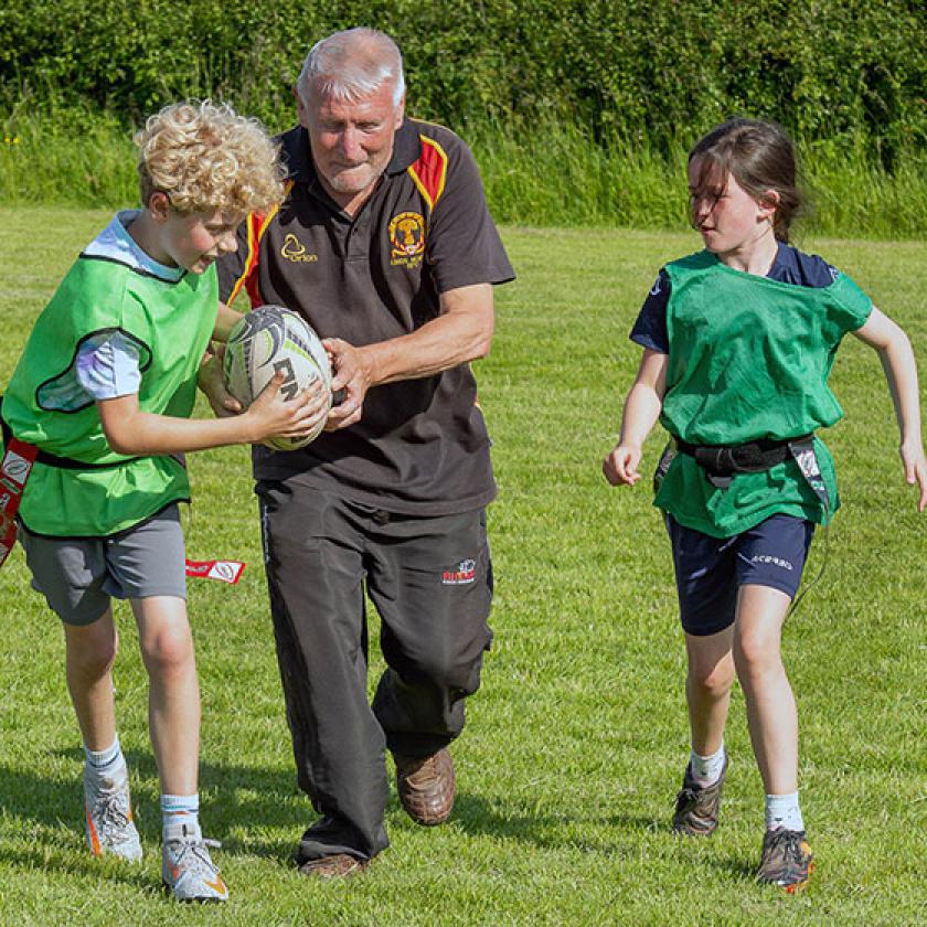 Ron Bruce, Annabel Hughes-McCorkell and Eli Squires playing rugby