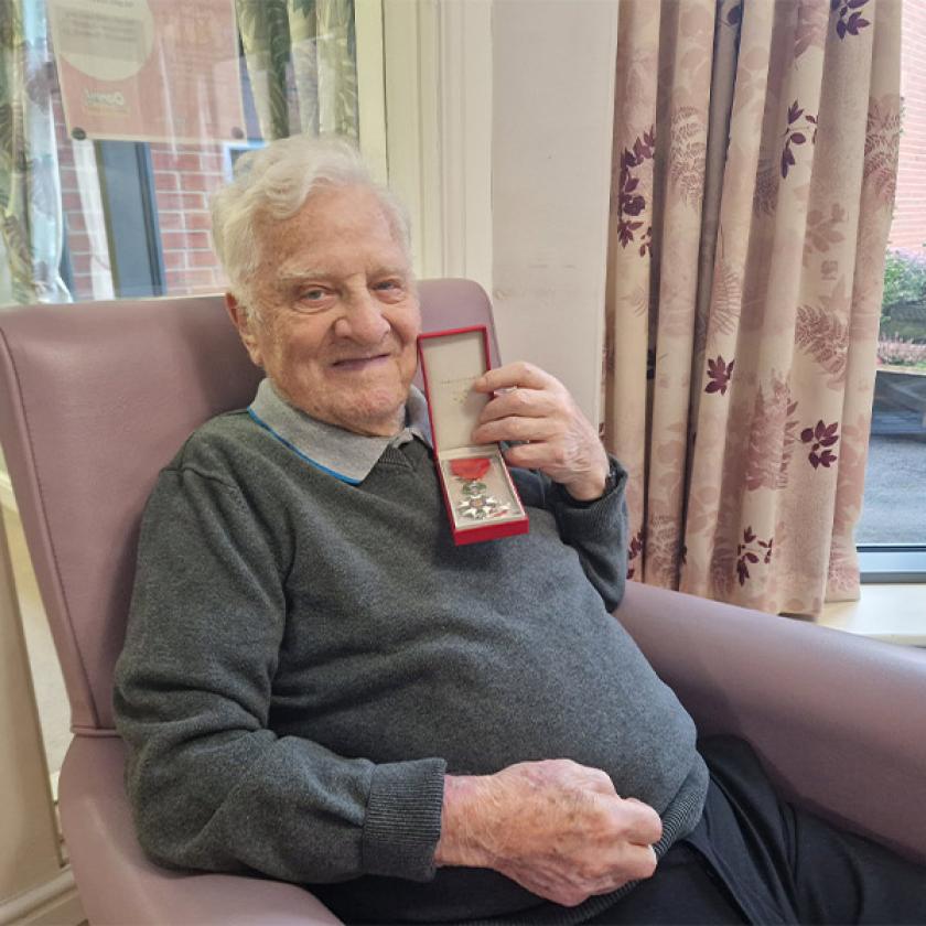 Redhill Court resident Stanley showing his medal