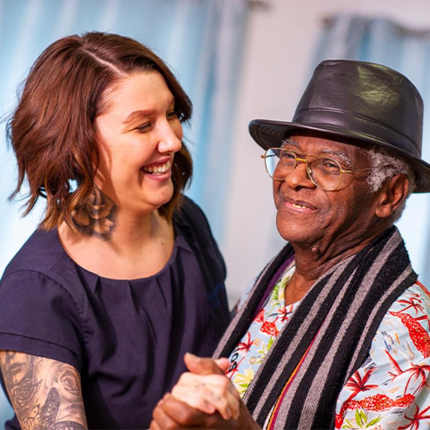 Sanctuary Care staff and resident dancing