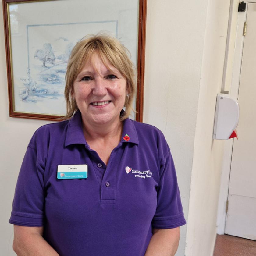 Teresa Arnold smiling in her purple Sanctuary Care uniform