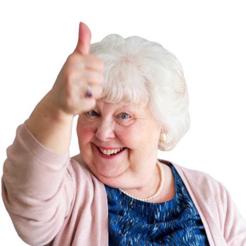 A care home resident puts her thumb up and smiles