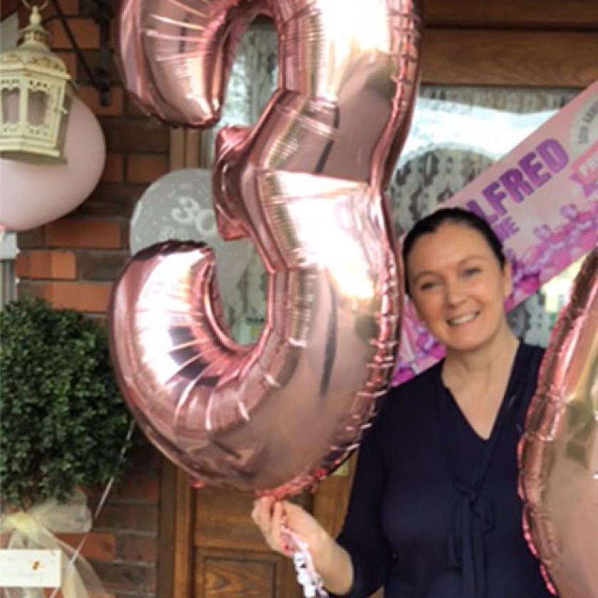 Carer, Cheryl, celebrates her 30th work anniversary with balloons