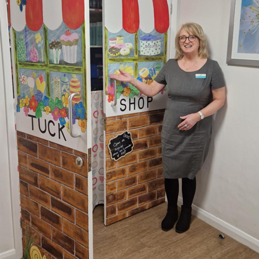 Gail Jenson and the tuck shop she hand-painted for residents
